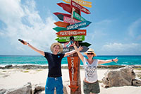 people at cozumel beach with signs in the back